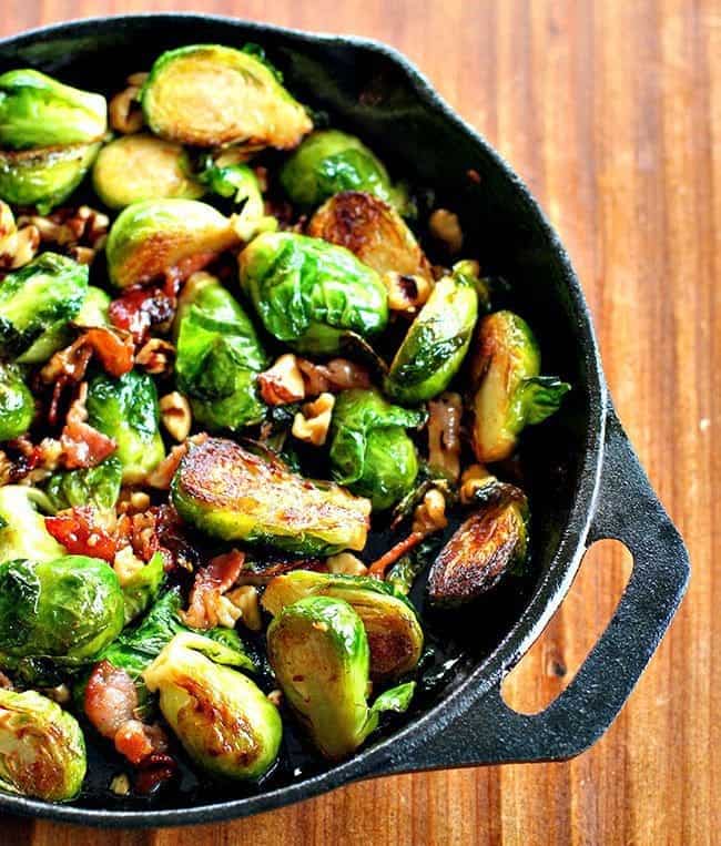 Large frying pan with bacon, walnuts and honey brussels sprouts with melted honey