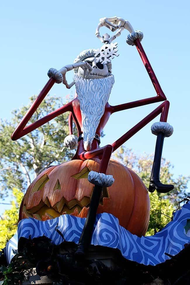 a figure of creepy elf sitting in a haunted pumpkin holding snowflake near the nose 