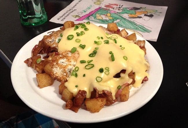 breakfast hash with bacon, melted cheese and chopped green onions on top