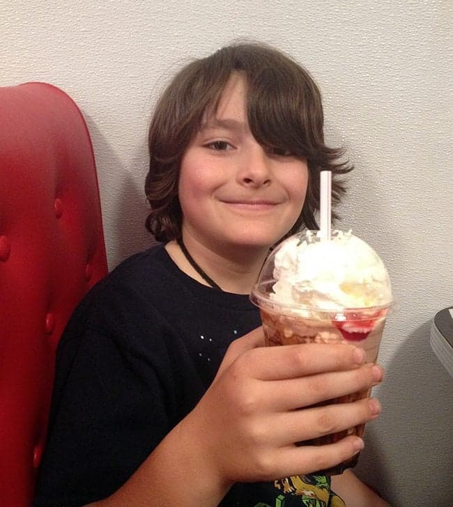 young boy holding his milkshake at the Downtown Diner