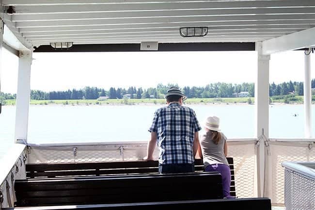 dad and his daughter standing in the boat watching the ocean