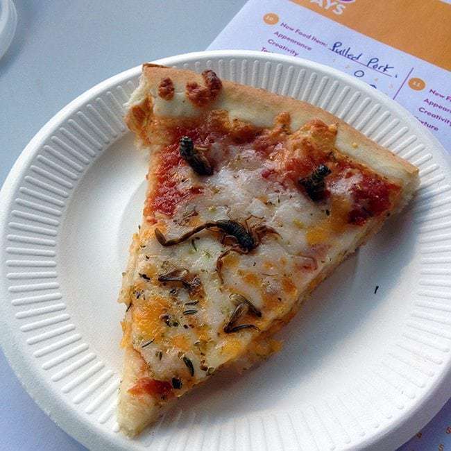 a slice of scorpion pizza in a white plate