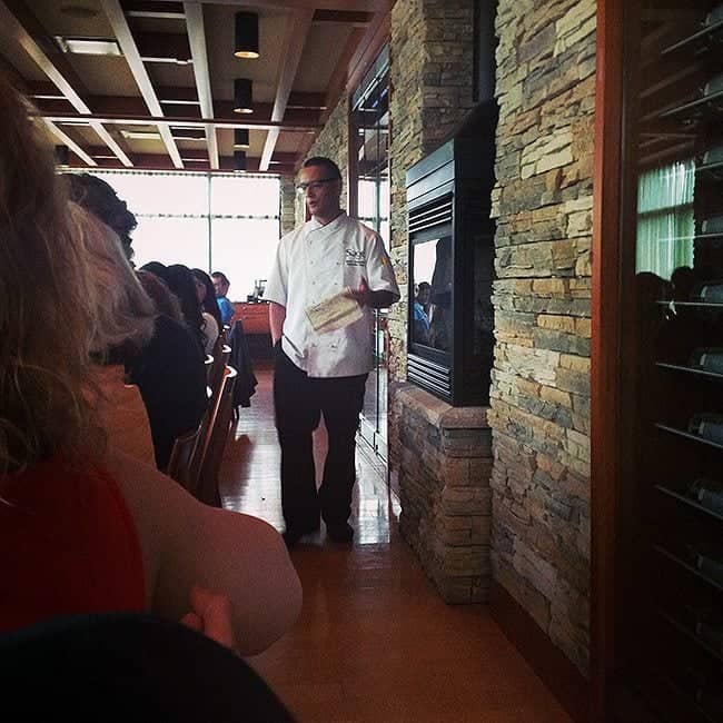 chef standing near the wall holding a piece of paper and discussing something