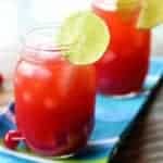 close up Cherry & Raspberry Bourbon Lemonade on mason jars garnish with a slice of lemon