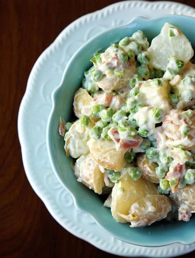 close up of Pea Salad with potatoes, garlic and bacon Aioli in a blue bowl