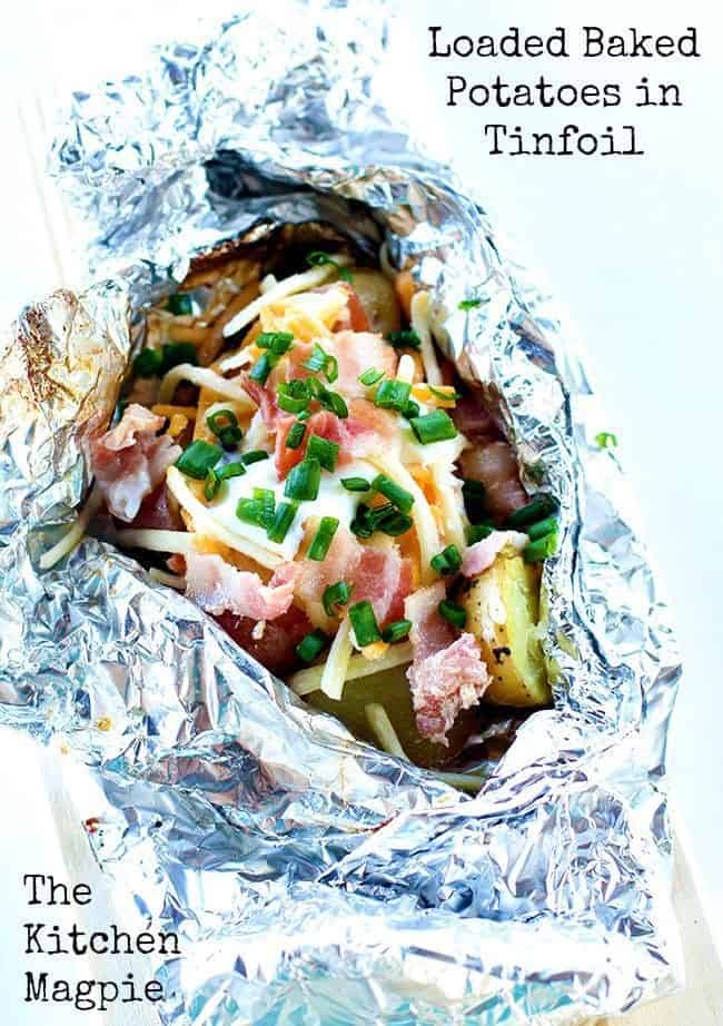 Amazing loaded baked potatoes done on the campfire, your BBQ grill or in the oven. The tinfoil packet makes clean up and cooking so easy! #camping #potatoes #bacon