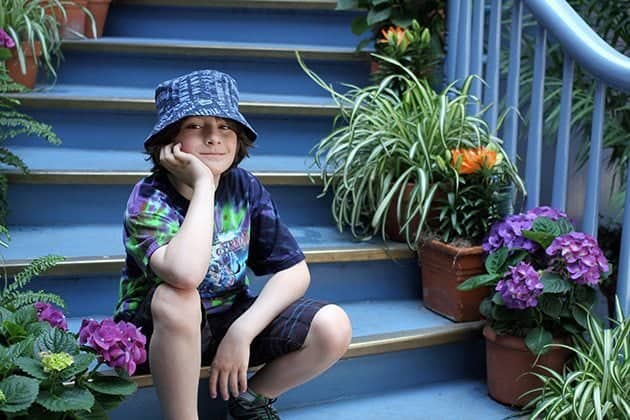 young boy sitting in one of the stairs of Court des Anges at Disneyland