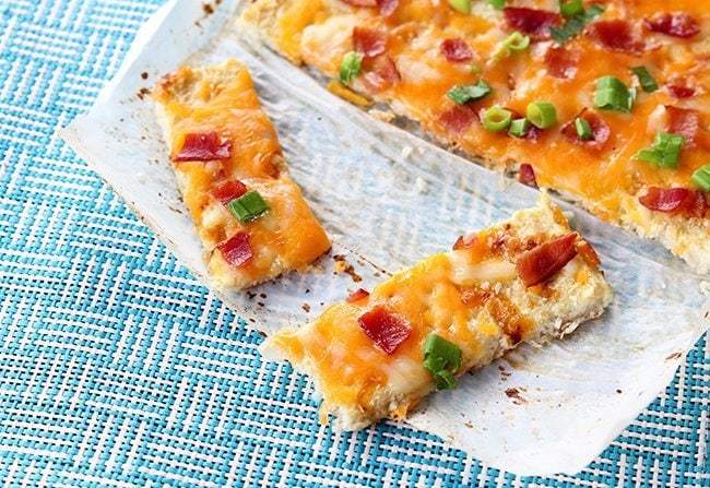 close up of Fully Loaded Cauliflower Garlic Bread on parchment paper