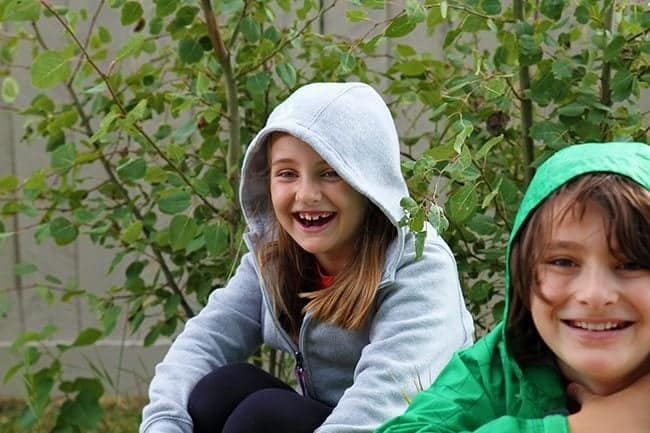 closer look of two young kids having fun outside the house while sitting