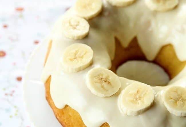close up Banana Pudding Cake With Cream Cheese Glaze and sliced banana toppings