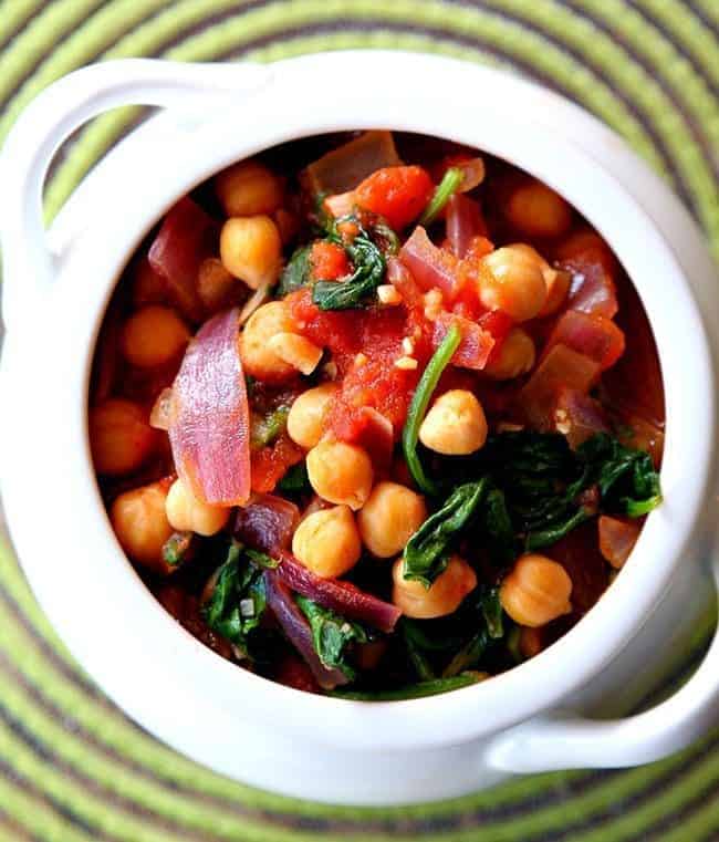 top down shot of Spinach, Tomato & Chickpea Stew in a white pot like bowl