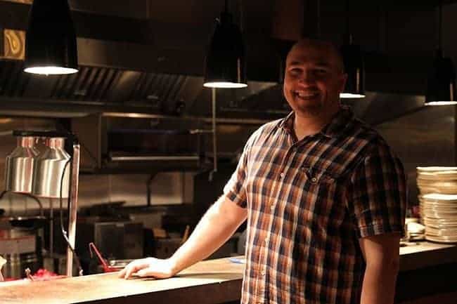 man standing smiling beside the kitchen table