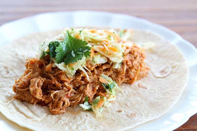 Crock pot Chicken Fajitas served on tortilla topped with Mexican Coleslaw and cilantro
