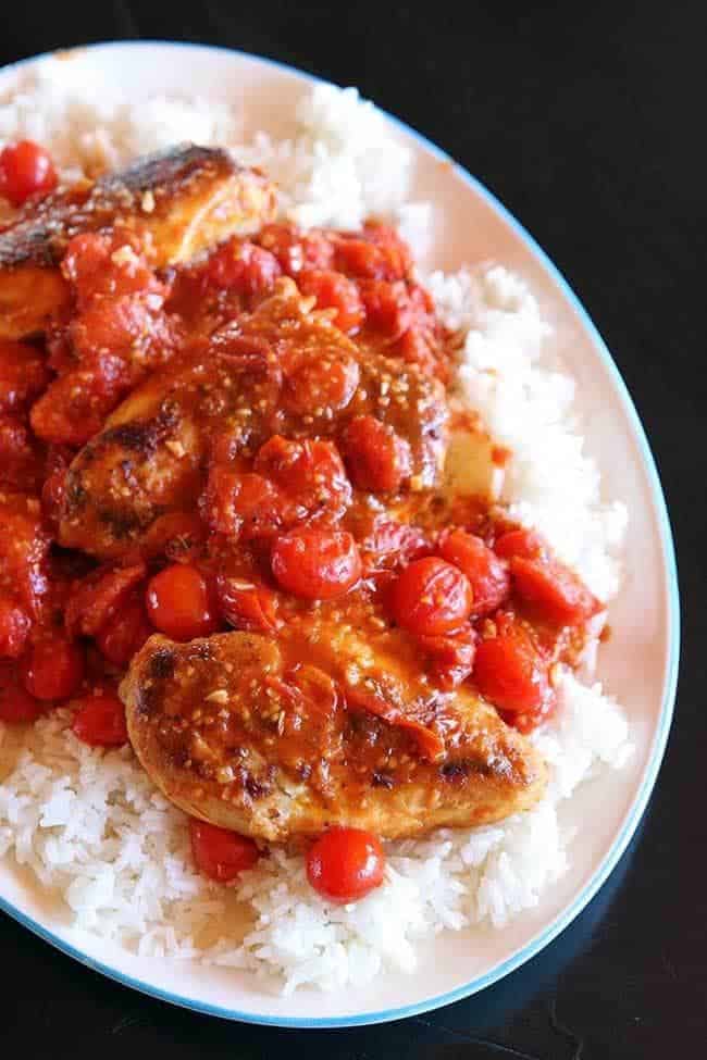 Top down shot of Smashed Tomato Chicken Served on top of Rice
