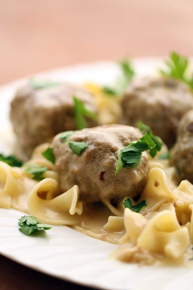 Close up of Turkey Swedish Meatball over noodles garnished with parsley leaves