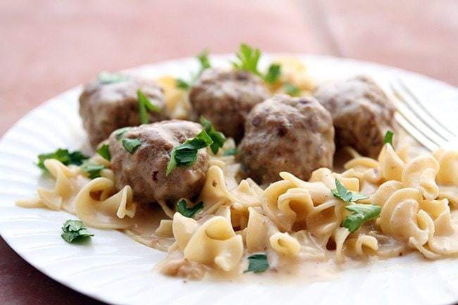 Close up Turkey Swedish Meatballs served over egg noodles garnished with parsley leaves