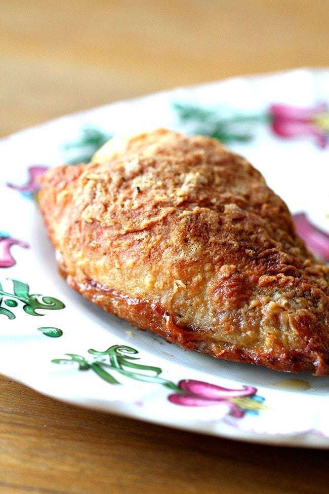 close up of Crispy Oven Fried Chicken piece in a white plate with floral design