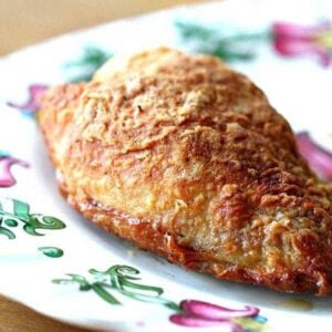 close up of Crispy Oven Fried Chicken piece in a white plate with floral design