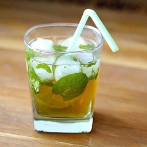 Maple Whiskey Mojito in a whisky glass with mint leaves and slice of lime on wood background