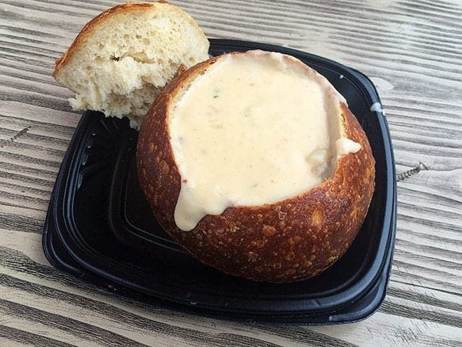sourdough bread bowl filled with clam chowder in a black plate