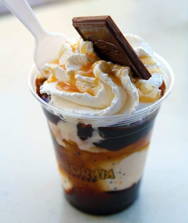 a cup of sea salt caramel and chocolate sundae topped with chocolate bar