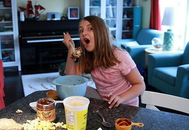 young girl wearing pink shirt holding a fork with Peanut Butter Snack Bites