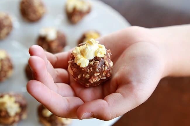 Close up of Peanut Butter Snack Bites with popcorn in hand
