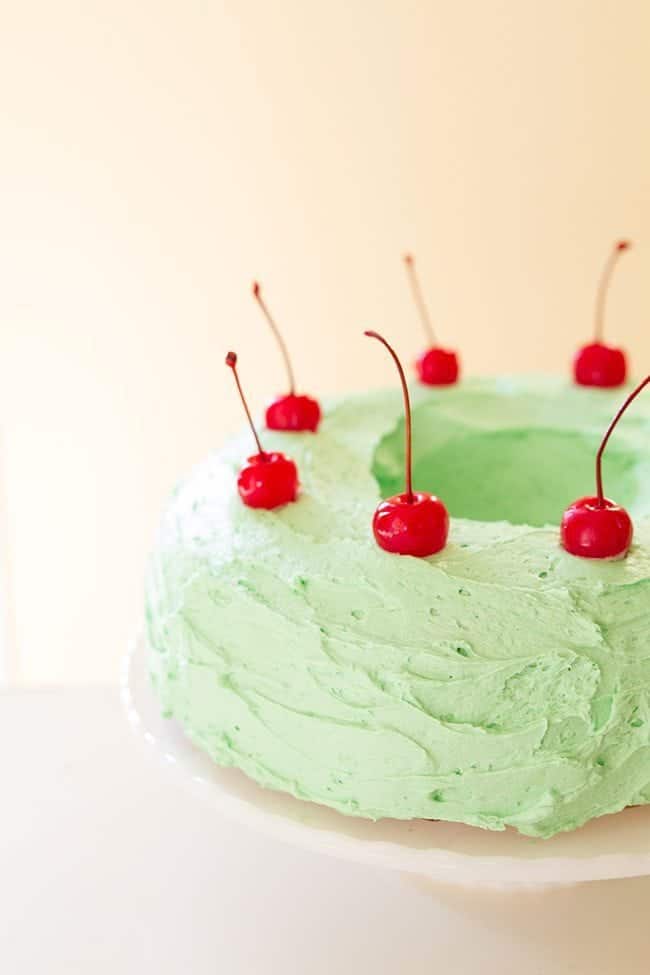 Watergate Salad Cake with frosting and cherries