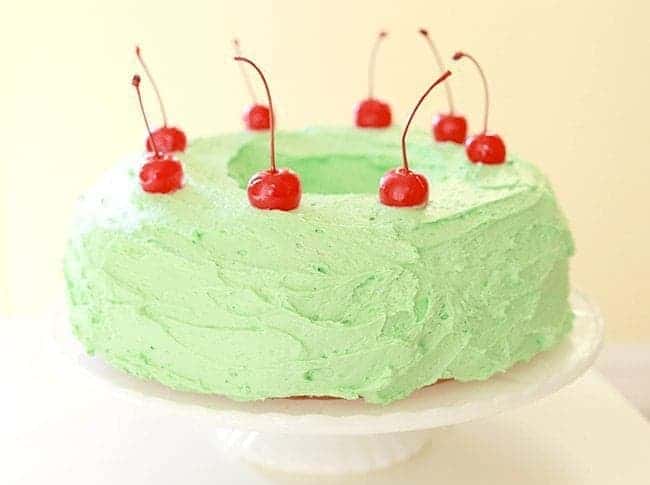 Watergate Salad Cake Garnish with Cherries on a White Cake Holder