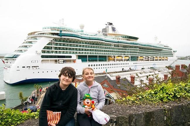 two kids sitting in the bench and at their back is the view of ship cruise