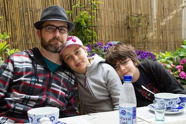 Dad and his kids sitting, bowl and bottled water in the table