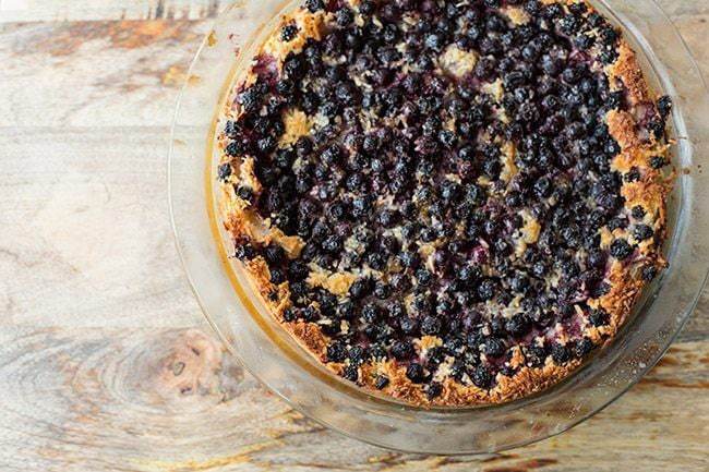 top down shot of Impossible Pie with Saskatoon Berries in a Pyrex pie dish on wood background
