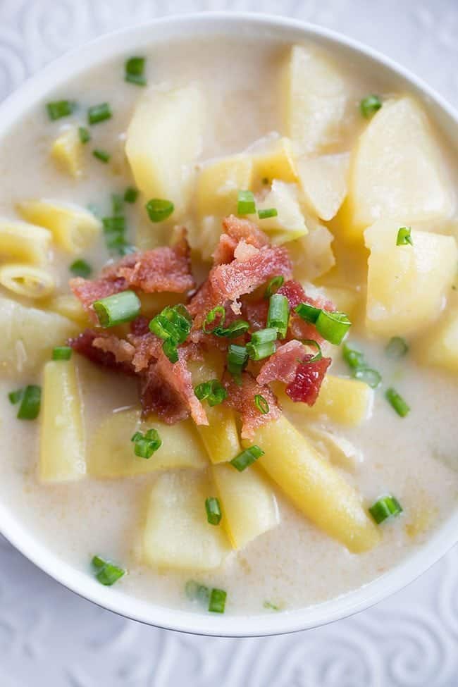 top down shot of Creamy Yellow Bean & Potato Soup with green onions and bacon on top