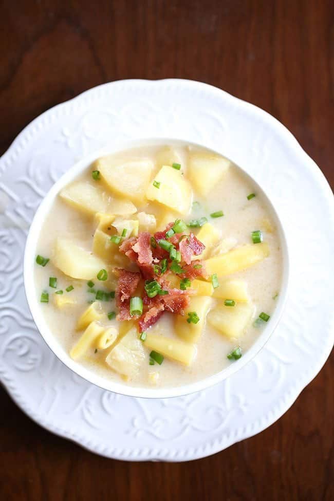 Creamy Yellow Bean & Potato Soup in a white bowl, topped with green onions and bacon