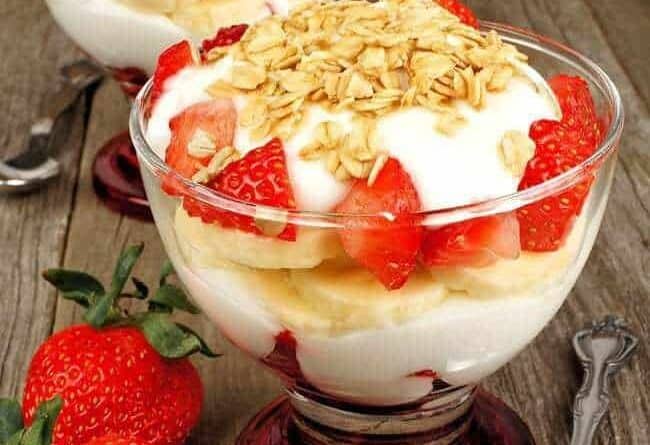 Toasted Oats Muesli sprinkled on top of yogurt with sliced strawberries