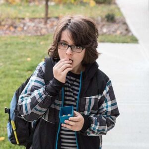 boy with his backpack eating Soft Baked Granola Bites