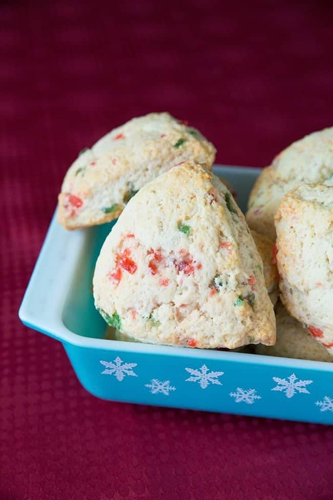 blue snowflake Pyrex tray with pieces of Christmas Cherry Scones on a red background