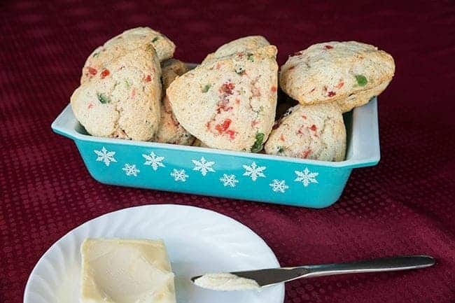 Christmas Cherry Scones in a blue snowflake Pyrex tray and a white plate with butter