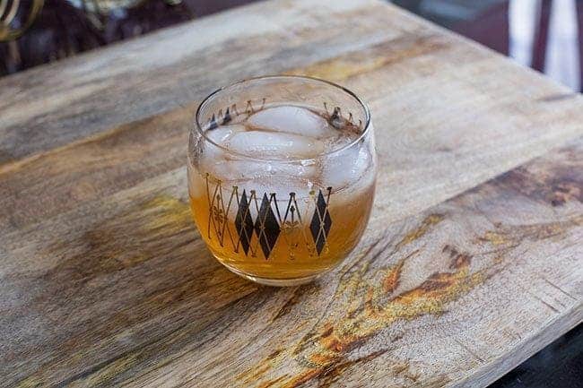 The Log Cabin Cocktail in a retro shot glass on a wood background