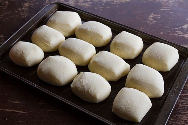 baked Sweet Dinner Rolls in cookie sheets on wood background