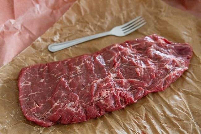 fresh Flat Iron Steak with a fork beside it