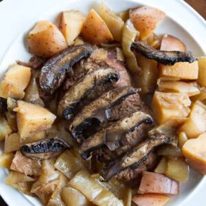 close up Flat Iron Steak with Portobello Mushrooms & Potatoes in a white plate