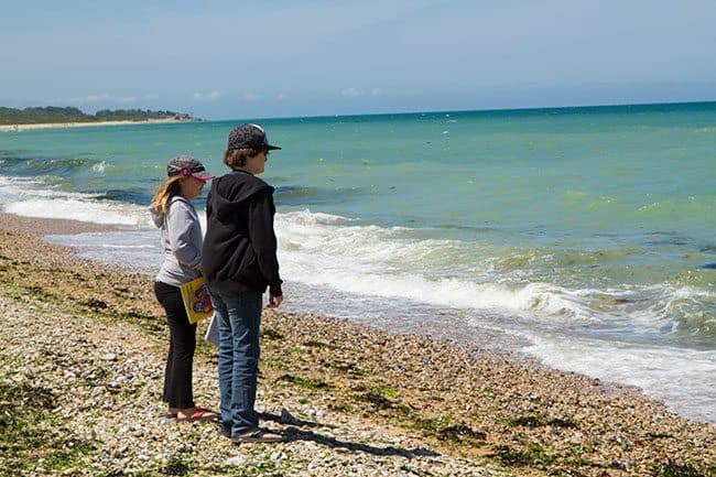 two kids standing near the ocean