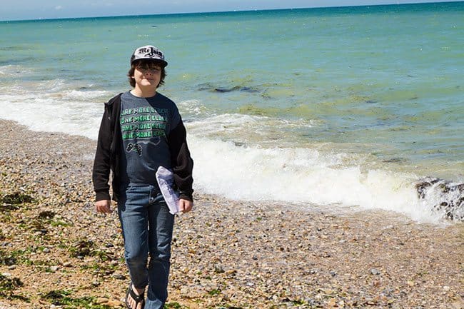 young boy standing near the ocean