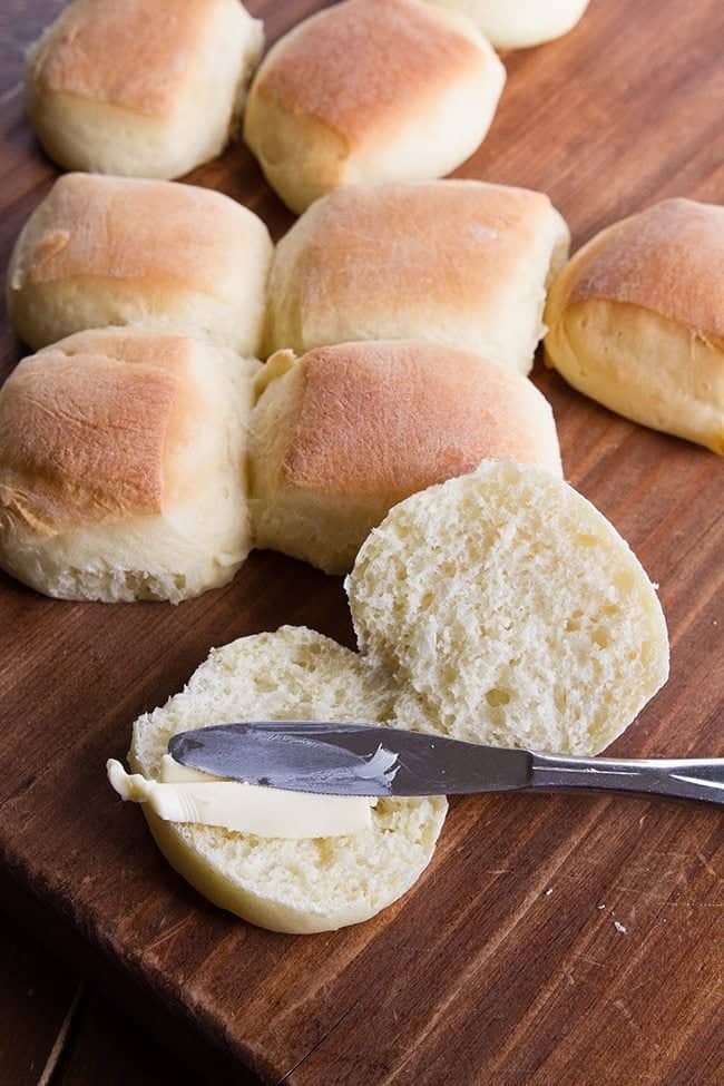 close up spreading honey butter into Sweet Dinner Rolls using spread knife