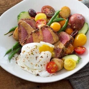 Chia Crusted Nicoise Salad Square in a white plate with poached egg