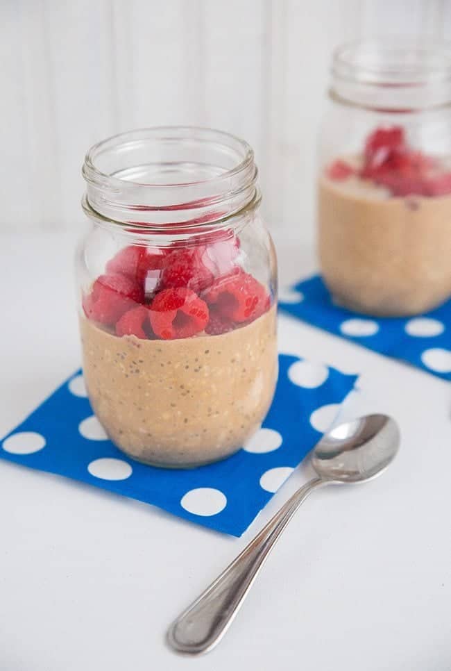 Spiced Chocolate Raspberry Refrigerator Oatmeal on Jars with Blue Paper Underneath