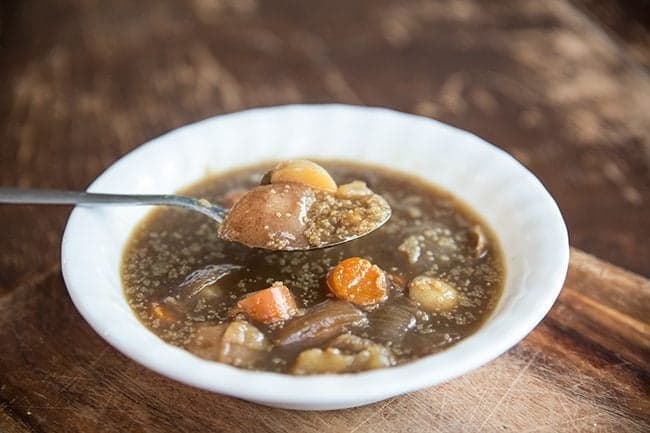 Spooning Amaranth Vegetable Soup from White bowl 