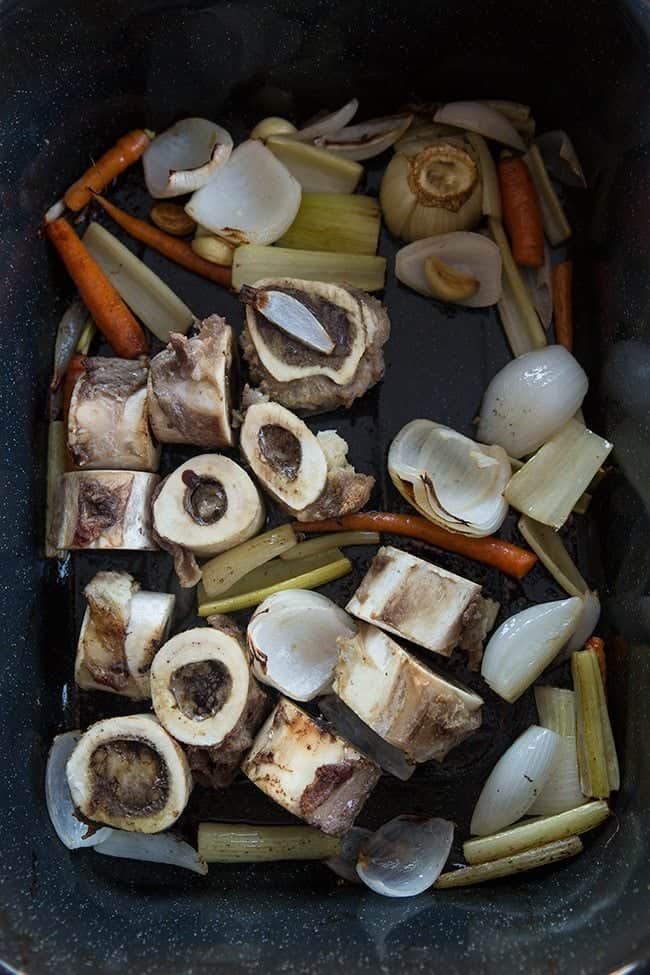 Roasted bones and chopped vegetables in Crockpot