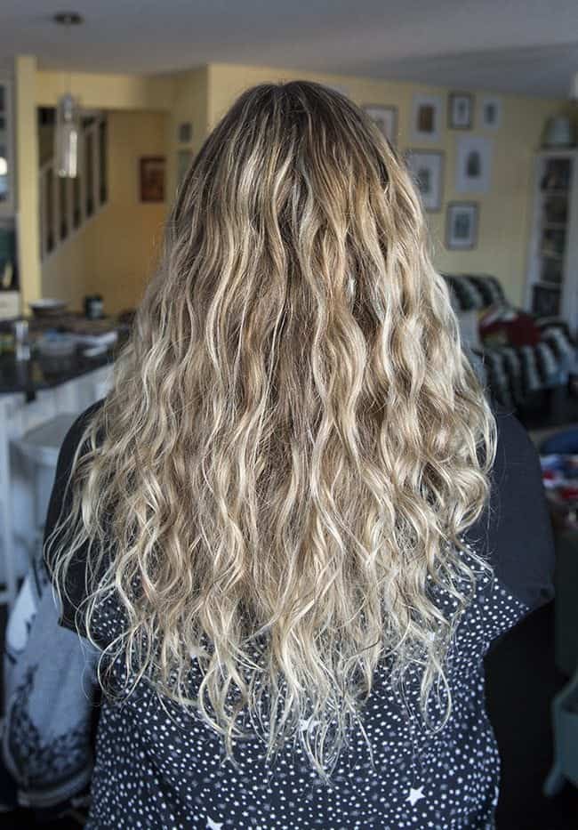 woman facing back showing her long blonde wavy hair
